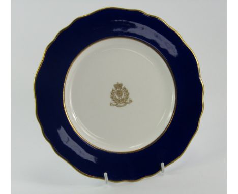 A Royal Worcester porcelain plate for The Lancashire Fusiliers, gilt decorated centrally with a crest and motto, within a cob