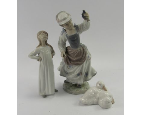 A Lladro porcelain figure of a lady, modelled standing holding a bird in her hand, 25.5cm high, together with a Nao figure of