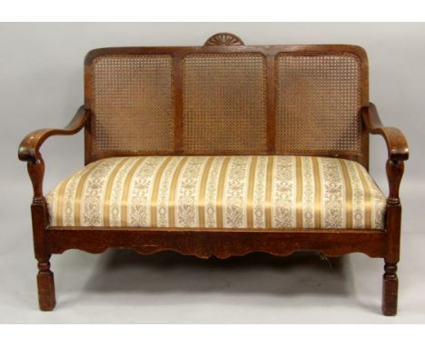 A 1930s oak two seater sofa, with cane back, 129cm wide.