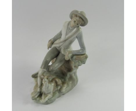 A Lladro porcelain figure of a travelling youth, modelled seated on a tree bough with a dog at his side, impressed marks, 20c
