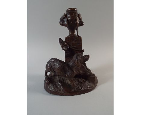 A Carved Black Forest Candlestick in The Form of A Dog Standing Beside Urn on Plinth. 19 Cm High. 