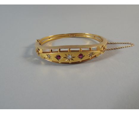 A 15 Carat Gold Bangle Set with Three Diamonds and Two Rubies. Total Gross Weight, 14.7 g. 