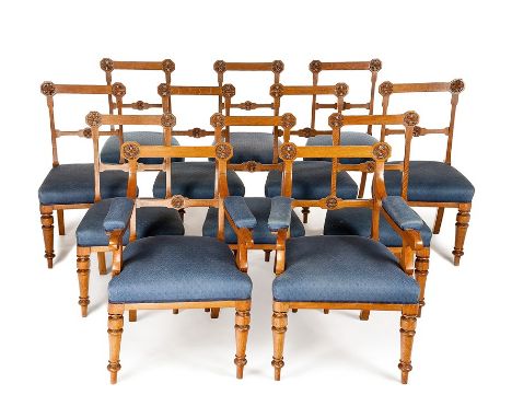 A set of twelve Victorian Gothic Revival carved oak dining chairs including a pair of open armchairs
The pierced backs with p