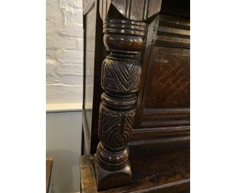 A Charles I carved oak press cupboard
Geometrically inlaid with holly and bog oak, the rectangular moulded cornice above a lu