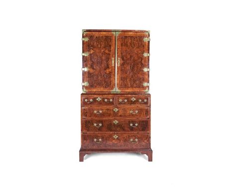 A George I burr walnut, featherbanded and crossbanded cabinet on chestThe brass bound upper part with rectangular top and qua