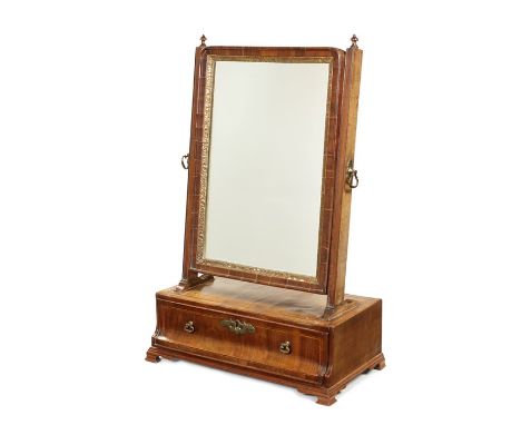 A Queen Anne walnut and chequerbanded toilet mirror
The replaced plate with a leaf carved slip and moulded swing frame, the r