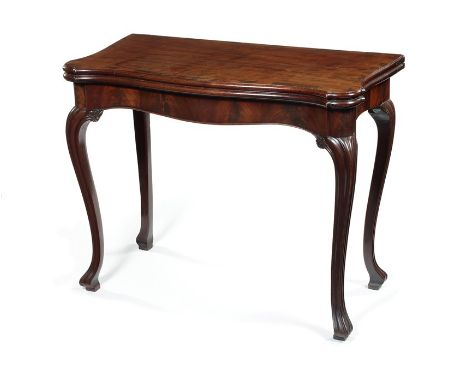 A George III mahogany carved and crossbanded concertina-action serpentine card table in the French tasteThe shaped rectangula