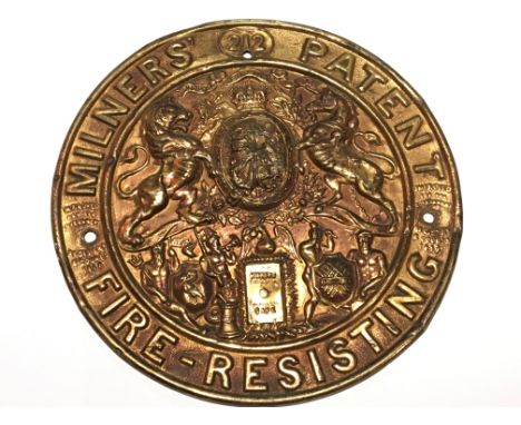 A pressed brass safe and lock makers plaque the centre with Royal Coat of Arms. Diameter 21cm