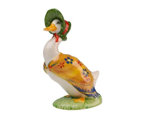Prototype duck decorated in a deep yellow shawl with blue and white flowers, red florets, and a green bonnet with a red ribbo