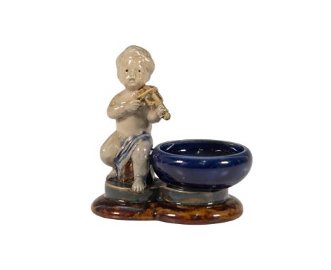 Glazed stoneware figural open salt cellar modeled as a putto playing the violin. The figure is shown standing beside a circul
