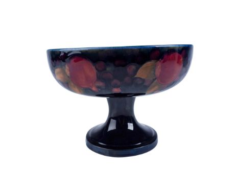 This striking centerpiece features a deep blue ground showcasing a vibrant design of pomegranates and berries, detailed with 