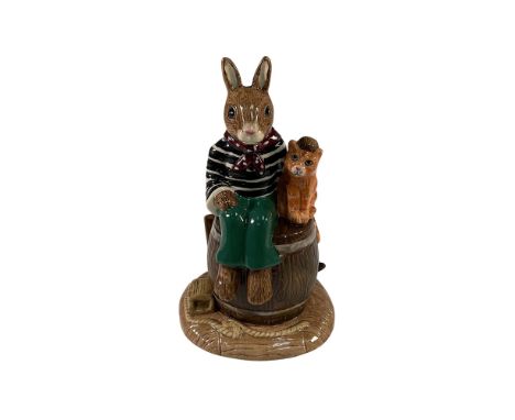 This delightful Royal Doulton Bunnykins figurine is a charming depiction of a young sailor bunny seated on a barrel alongside