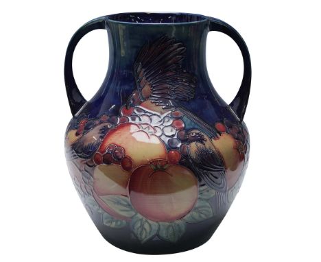 This two-handled vase is decorated in the Finch pattern, which features detailed depictions of finches amidst an arrangement 