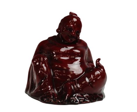 A rare and highly collectible example of Royal Doulton's flambe ware, this figurine titled The Smiling Buddha was designed by