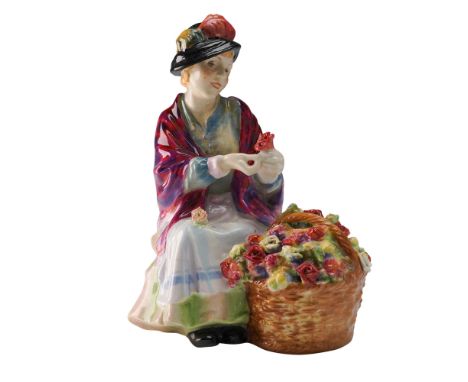 All a' Bloomin' HN1457 by Royal Doulton features a seated flower seller arranging a red bloom beside a large wicker basket fi