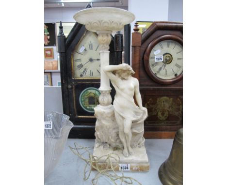 An Alabaster Figure of a Scantily Clad Maiden, circa 1900, stood beside a wall, as a table lamp, 43cm overall height.