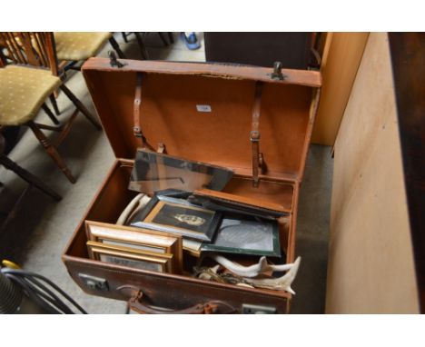 A leather bound suitcase and contents of various pictures frames, hunting trophy etc.