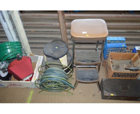 A step stool; and a hose and reel; and one other step stool 