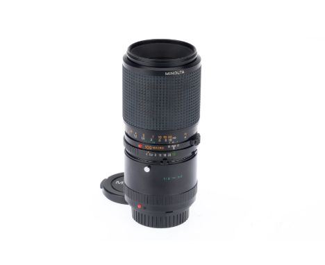 A Minolta MD Macro f/4 100mm Lens, black, serial number 8010762, barrel VG, optics VG, with attached 1:2 converter, with caps