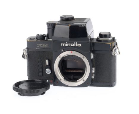 A Minolta XM 35mm SLR Camera Body, black, serial number 2117744, body G, some brassing to edges, shutter works but does alway