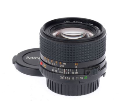A Minolta MD f/2.8 20mm lens, black, serial number 8003542, barrel VG, optics VG, with caps.
