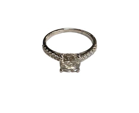 A platinum diamond solitaire ring, set with diamond shoulders, approximate diameter of the diamond 7.4 mm. CONDITION REPORT: 
