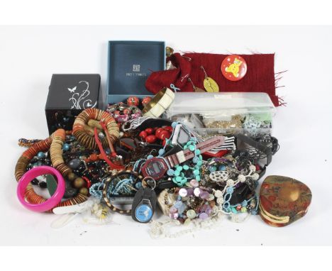 A large quantity of costume jewellery, including necklaces, a metal bangle, assorted beads and more, together with a glass pl