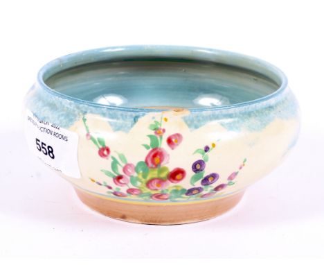 An Art Deco Clarice Cliff bowl, decorated with floral sprigs and bushes, marked to base 'Clarice Cliff Wilkinson ltd', 13cm d