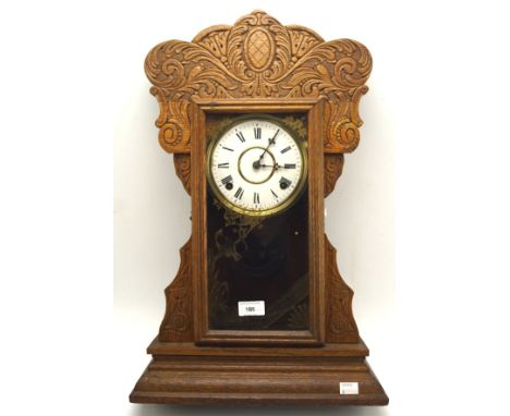 A 20th century carved wooden mantle clock, the dial with Roman numerals denoting hours, 58cm high