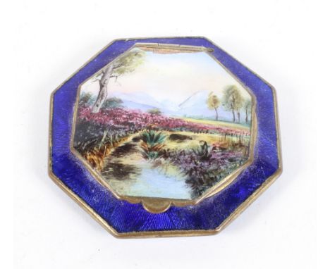 An early 20th century enamel compact, of octagonal form, the lid painted with a countryside landscape scene, the case decorat
