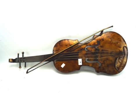 A contemporary metal wall hanging in the form of a violin, together with a matching bow, 78cm long