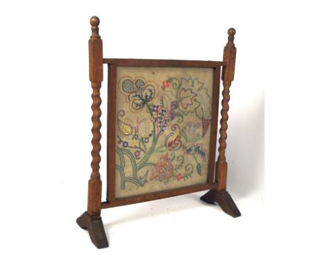 A 20th century wooden fire screen with barley twist supports and needlework panel, 72cm high