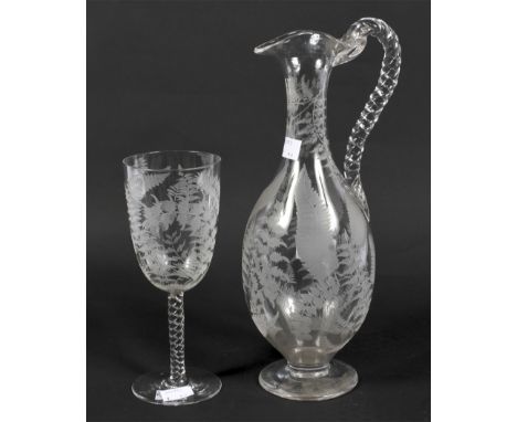 A 19th century engraved glass pouring jug and matching glass. each with highly detailed decoration depicting ferns, 30cm high