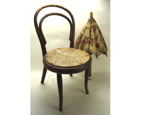 A child's bentwood cafe chair and a parasol, the first with pierced wood seat, height 64cm, the second with a canvas shade de