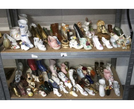 A large collection of ceramic and pottery shoe and boot ornaments, of varying sizes and designs, also including metal example