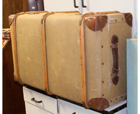 An early 20th century canvas and wood bound travelling trunk