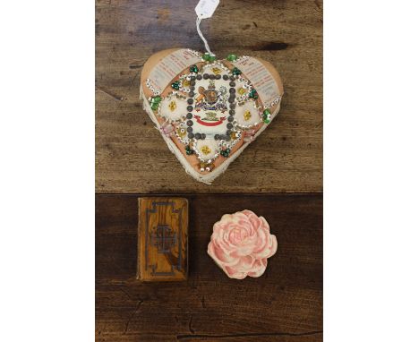 A war time embroidered heart shaped sweetheart token cushion, a wooden covered Bible and paper calendar 