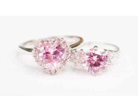 Two sterling silver pink coloured single stone dress rings, one with a multi-faceted heart shaped stone with a stone chip gal