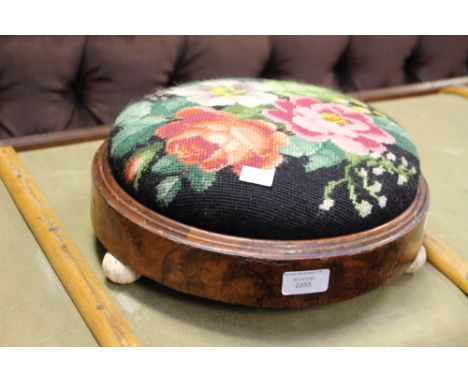 A Victorian walnut footstool with ceramic toot knobs, a replaced tapestry top