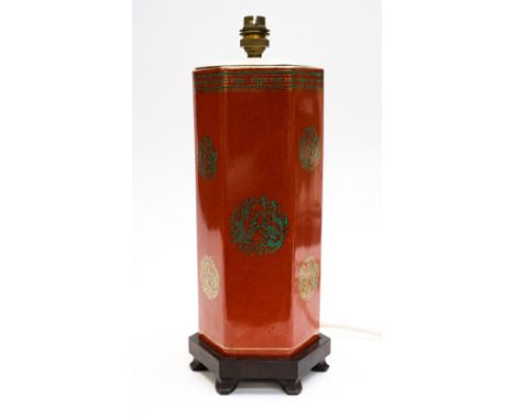 An Art Deco table lamp base, in Chinoiserie style on a dark red ground, carved wooden base, 35cm height.