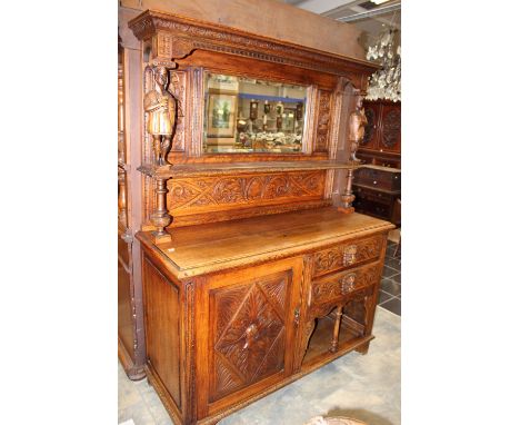 A late 19th Century oak chiffonier, in the Renaissance Revival style, fitted with a mirrored back, the upper section with car