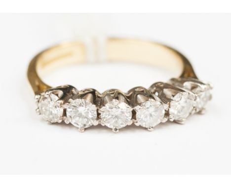 A six stone diamond ring on 18ct gold band.