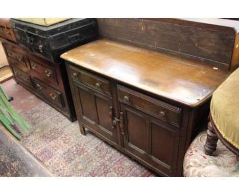 An Ercol elm and oak sideboard, fitted with two drawers over two doors, 85cm high, 120cm wide, 48cm deep