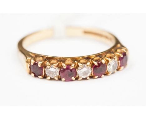 A ruby and diamond seven stone ring, diamonds (three equals approximately 0.2cts) 18ct gold, and four rubies, .28 cts approxi