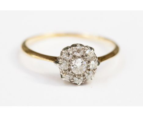A diamond cluster ring with central old cut stone of approximately 0.1ct surrounded by eight smaller stones.