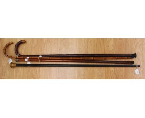 An ebonised walking cane with gilt metal pommel dated 1916, an antique malacca swordstick and two crook handle walking canes 