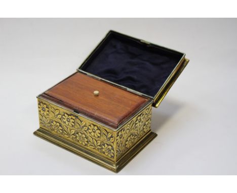 An early 19th Century brass tea caddy with repouse detailing leaves and flowers, two compartment caddy size 15.5 cm approx, h