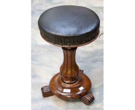 An early Victorian rosewood piano stool, the circular revolving adjustable seat, raised platform pedestal base