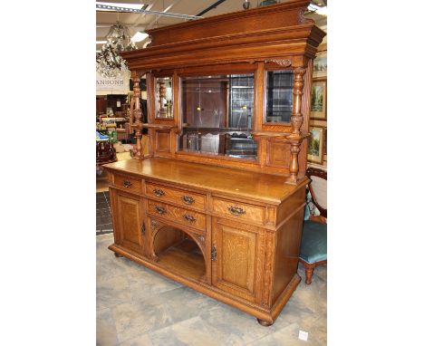 A late Victorian oak mirror backed sideboard, circa 1895, the back with three bevelled edge mirrors, the cornice above suppor