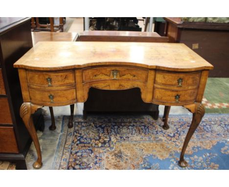 A George V Queen Anne style walnut dressing table, circa 1930, serpentine form, fitted with a central drawer and four short f